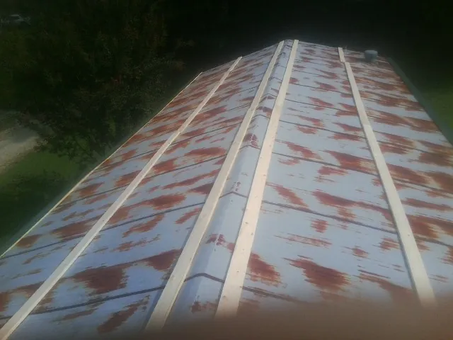 Rusted metal roof panels with new wood purlins before replacement — Storm Damage Roof Repair in Alpha by Roofing Brothers